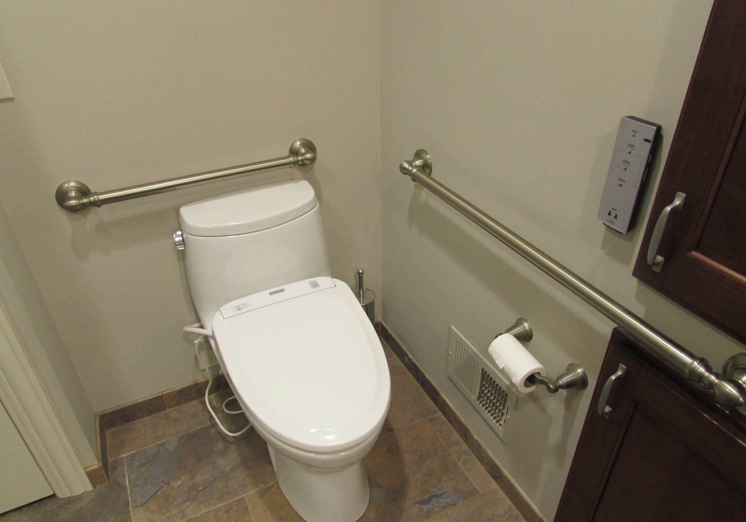 Picture of toilet with bidet. Grab bars behind and to the side of toilet.